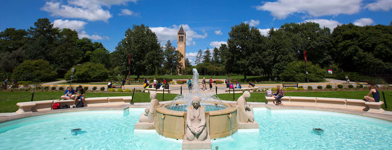 People sit on benches around the Fountain of the Four Seasons